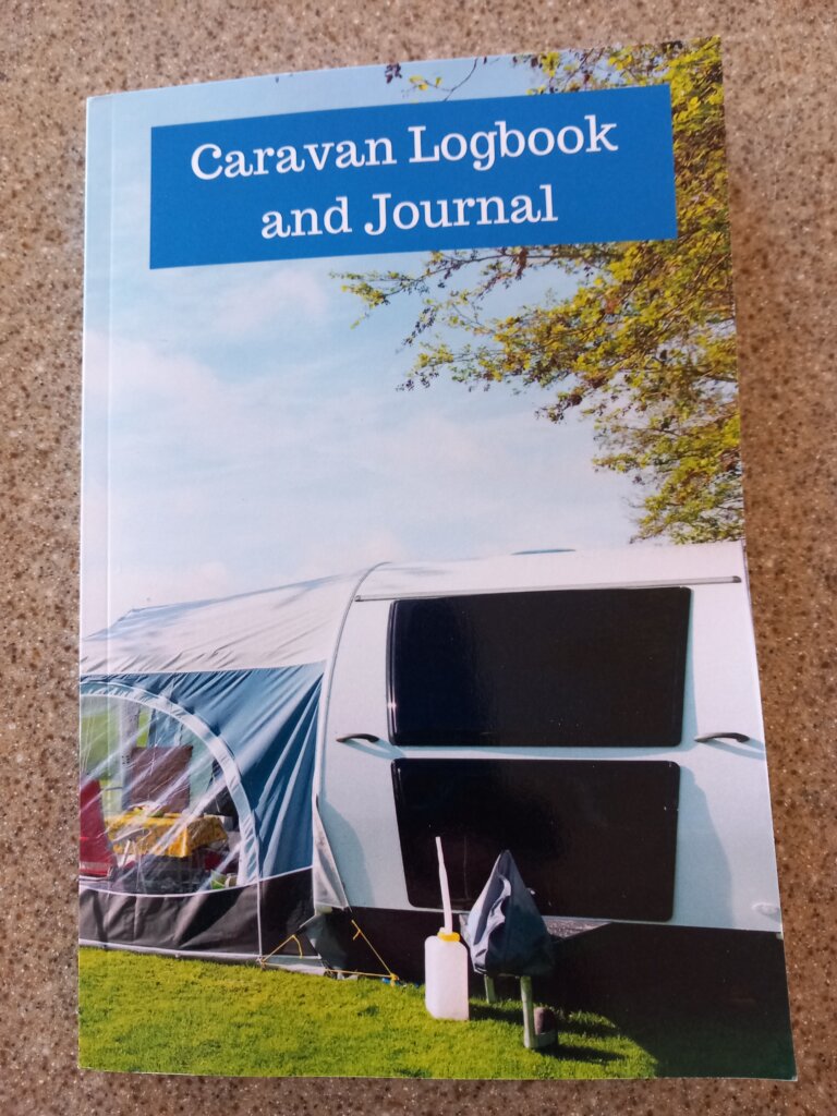This photo shows the front cover of my caravan logbook. It shows a caravan with an awning attached.