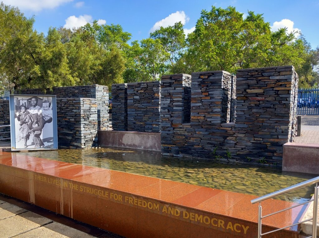 This image shows the granite memorial to Hector Pieterson with the iconic image of him being carried away from the riots with his distraught sister running alongside
