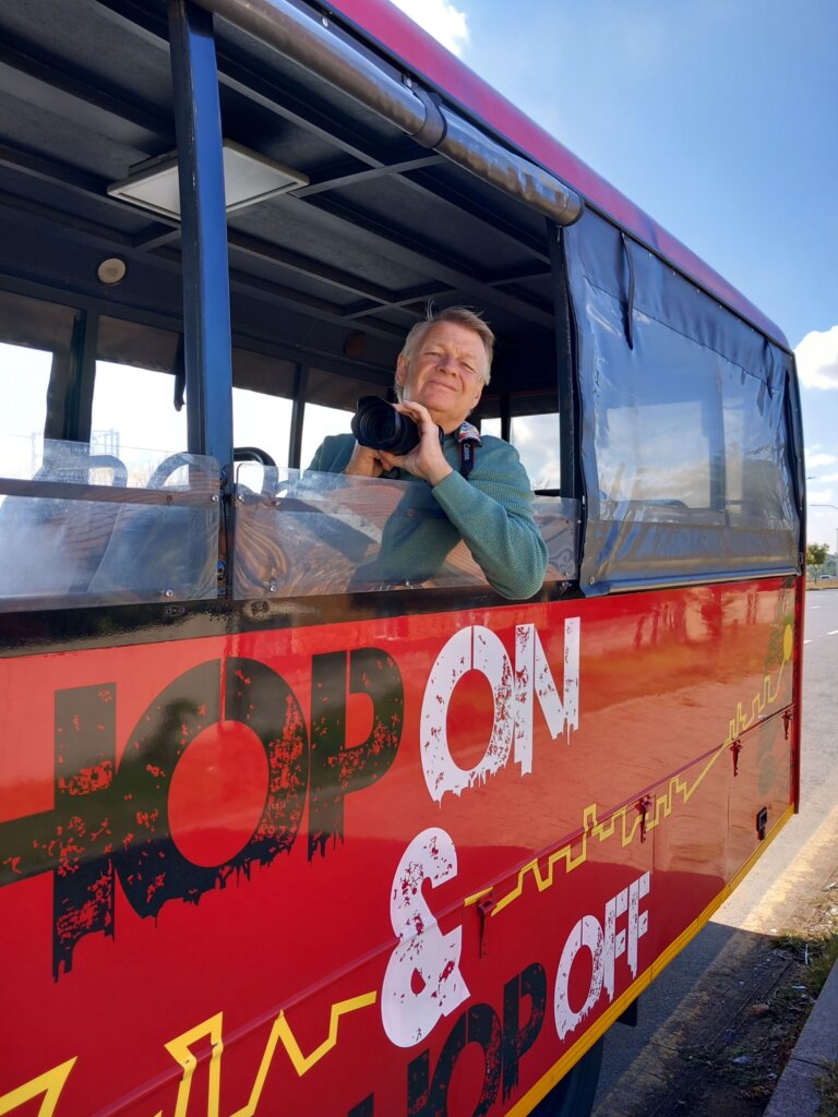 This image shows Mark leaning out of the window of our minibus. He is holding his camera ready to take a photo of Orlando Towers