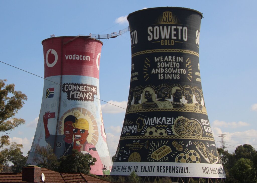 This image shows two painted cooling towers with a high wire strung between them