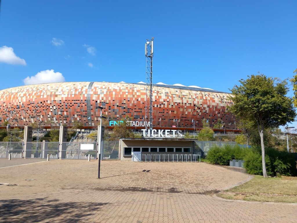 This image shows the ticket office and entrance to the distinctive terracotta-coloured FNB stadium