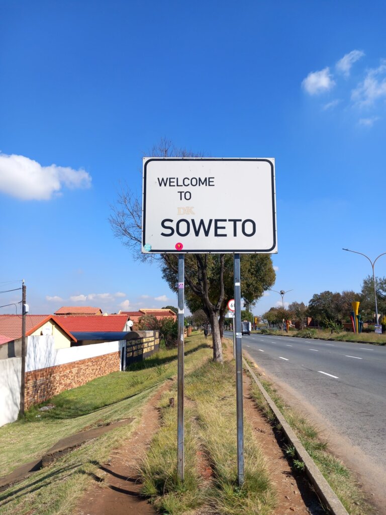 This image shows a welcome to Soweto sign with black print on a white background